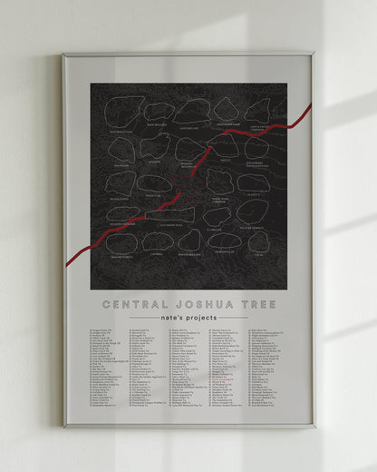 A black color, customized rock climbing ticklist poster for the JTree Central rock climbing location in Joshua Tree, California. The design has an overlay of crag topography, nature landscapes, and traced boulders, the person's name, and a list of bouldering problems at the bottom. Displayed as wall art in a living room.